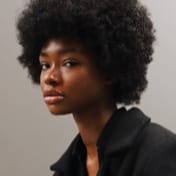 Imagem de uma mulher negra de cabelo afro, desenvolvedora front-end